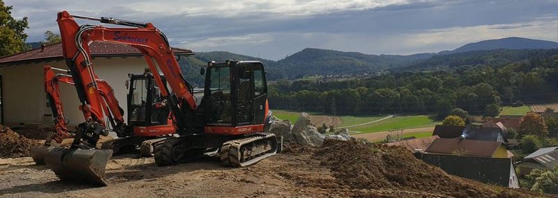 Bagger belädt einen Anhänger mit Erdaushub